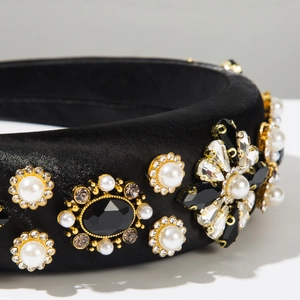 Gros plan d'un serre-tête en satin noir avec perles, strass et gemmes sombres