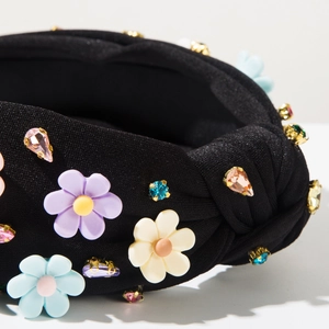 Détail macro du serre-tête baroque noué avec fleurs en strass et cristaux colorés