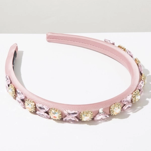 Detailed shot of a pink satin headband featuring crystal butterfly and rhinestone accents