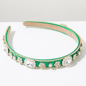 Close-up of green satin headband with white crystals and diamond flower decorations
