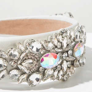 Macro shot of white satin headband featuring dense clear crystals and AB rainbow rhinestones