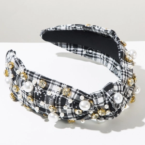 Detail of plaid fabric headband with pearls, crystals, and white snowflake patterns