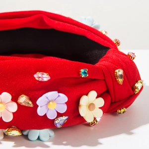 Détail d'un serre-tête baroque rouge avec fleurs 3D colorées et cristaux brillants