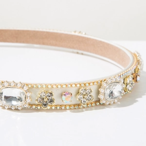 Close-up of Baroque headband with crystals, pearls, and gold flowers on white satin base