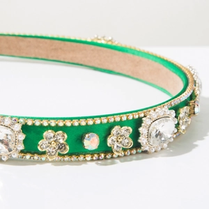 Detailed close-up of baroque emerald green satin headband with crystals and pearls