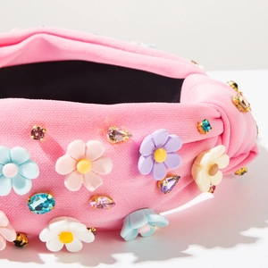 Détail d'un serre-tête baroque rose avec fleurs en résine et strass en cristal coloré