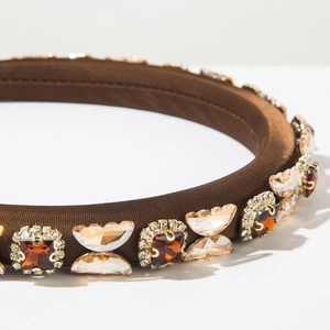 Detail view of brown satin headband with amber crystals and champagne butterfly gems