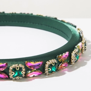 Detail of dark green satin headband featuring rhinestone butterflies and emerald stones