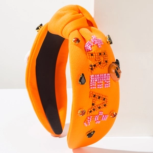 Detail of beaded 'TREAT' lettering and rhinestones on orange Halloween headband