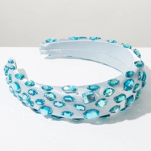 Detailed view of luxury wide headband featuring light blue satin and sparkling blue gemstones