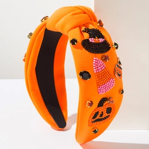 Detail of beaded wizard hat and pumpkin embroidery on orange Halloween headband