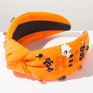 Detail of Halloween headband with beaded TRICK text and small white ghost charms