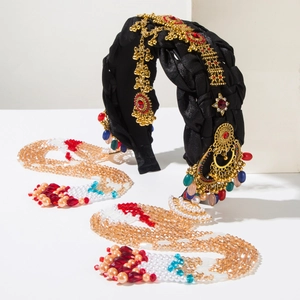 Close-up of ethnic style headband with golden metal floral charms and crystal tassels