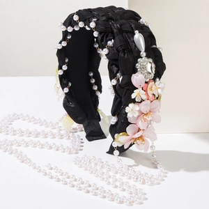 Detail of ethnic style braided headband with white pearls, resin flowers and heart rhinestone