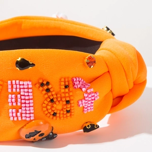 Close-up of orange Halloween headband with beaded pumpkin and sparkling rhinestones