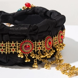 Detail of luxury ethnic headband with gold bells, red rhinestone and metal fringe tassels