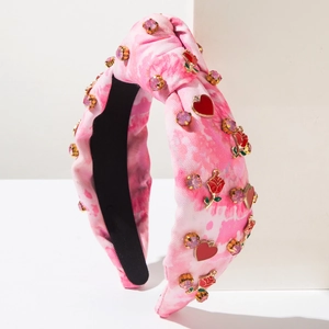 Detail of pink tie-dye knotted headband featuring crystal accents and heart pendants