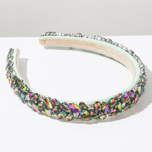 Détail d'un serre-tête baroque serti de strass multicolores sur tissu vert menthe