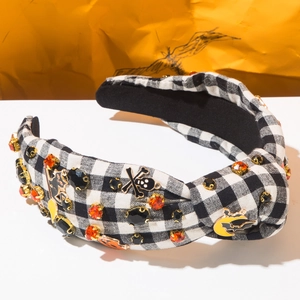 Détail d'un serre-tête d'Halloween avec strass orange, tête de mort et chauve-souris