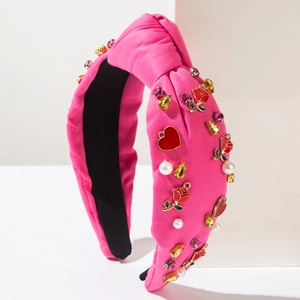 Close-up of pink knotted headband featuring red roses, pearls and crystal accents