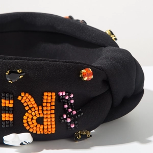 Detailed shot of Halloween headband with orange beads, rhinestones and ghost accents