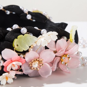 Detailed macro view of handmade floral headband with pink resin flowers and pearls