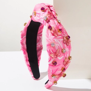 Detailansicht des rosa Batik-Haarreifens mit funkelnden Strasssteinen und Schmetterlingsdekor