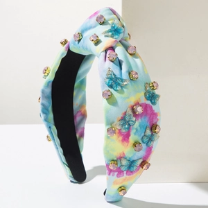 Detail eines Tie-Dye Stoff Stirnbands mit blauem Metallschmetterling und Strasssteinen