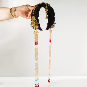 Detailed view of bohemian silk headband with golden filigree and long beaded tassels