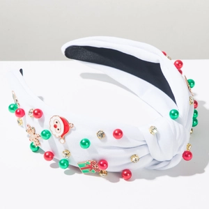 Dettaglio di cerchietto natalizio con tessuto bianco, perle, strass e ciondoli festivi