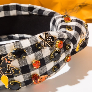 Détail du serre-tête d'Halloween avec chat noir, breloques de crâne et strass orange