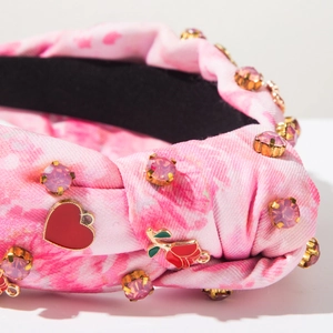 Macro shot of pink tie-dye headband featuring inlaid rhinestones and rose heart charms