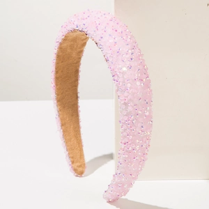 Close-up of a pink sequined headband with sparkling rhinestones and suede lining details