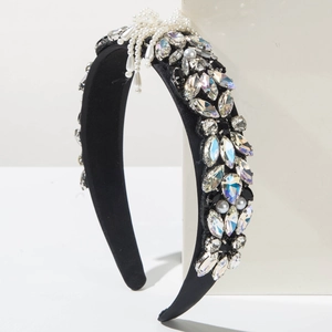 Macro shot of baroque headband with crystals and pearl bow on white platform