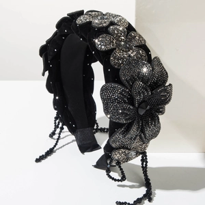 Detailed view of velvet headband with crystal flowers and hanging black bead tassels