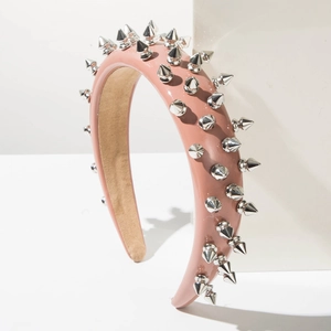 Detail view of pink leather headband featuring silver punk-style metal conical studs