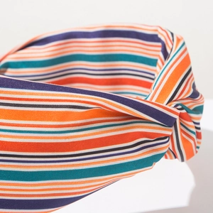 Dettaglio della fascia bohémien in tessuto a righe multicolore con elegante nodo intrecciato