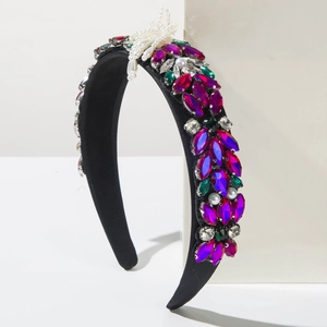 Detail of baroque headband featuring colorful crystals and white pearl bow embellishment