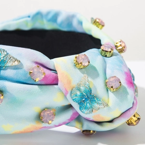 Detail eines Tie-Dye Stoff-Haarreifens mit rosa Strasssteinen und blauem Schmetterling
