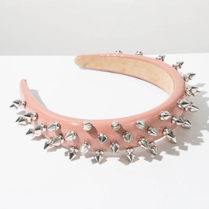 Detail of wide pink faux leather headband featuring silver metallic punk cone studs