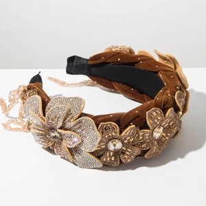 Detailed close-up of brown velvet headband with 3D floral crystals and tassel fringe