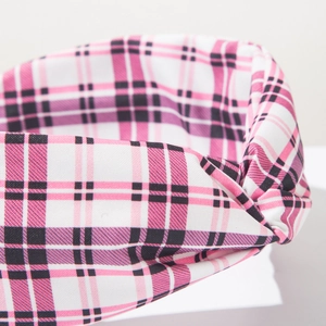Dettaglio del cerchietto in tessuto a quadri rosa e nero con nodo alla moda