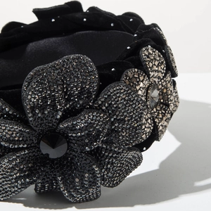 Detailed macro view of three 3D velvet flowers with shimmering rhinestones on a headband