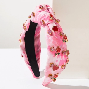 Pink and white tie-dye knotted headband with rhinestones, hearts, and rose ornaments