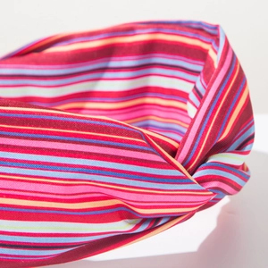 Dettaglio della fascia in tessuto a righe colorate con elegante nodo stile bohémien