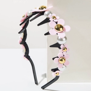 Détail d'un serre-tête antidérapant avec fleurs en résine et perles nacrées