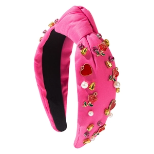 Rose red knotted headband with pearls, roses, and crystals on a polished white background