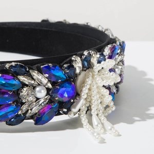 Detailed close-up of Baroque velvet headband with colorful rhinestones and pearl tassels