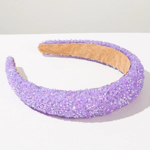 Close-up of purple rhinestones and khaki velvet lining on a thick padded headband