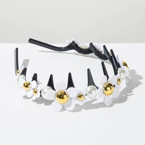 Détail de fleurs blanches et perles sur un serre-tête ondulé avec dents antidérapantes
